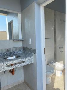 a bathroom with a sink and a toilet and a mirror at Casa del Sol in Salta