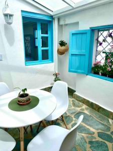 萊瓦鎮的住宿－Clareman，庭院配有白色的桌椅和蓝色的窗户。