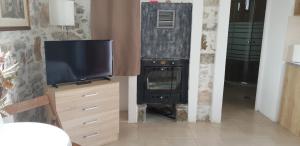 a living room with a television and a wood stove at Vilaeti Artemis in Agios Konstantinos