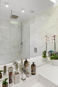 a white bathroom with a shower and a sink at ONE Herastrau Park in Bucharest