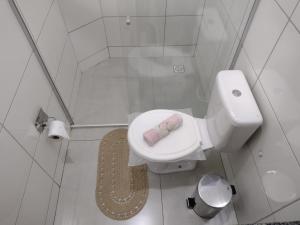 a bathroom with a toilet with a towel on the seat at kitnet Ragnarok in Barão de Cocais