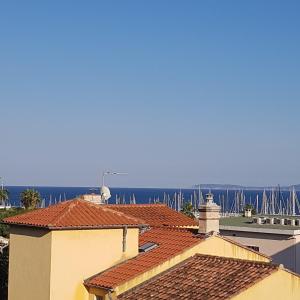 una vista de los tejados de los edificios y del océano en La Caravelle Vue Mer et Wifi, en Le Lavandou