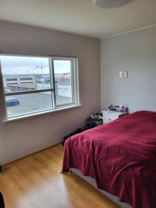 a bedroom with a bed and a large window at Reynidalur apartments in Njarðvík
