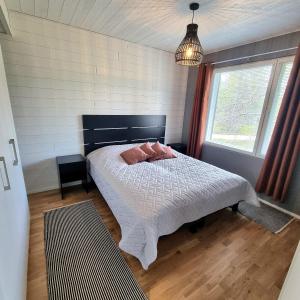 a bedroom with a bed with pink pillows on it at Holiday homes Ruka in Ruka