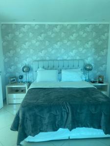 a bedroom with a large bed with blue walls at Casa de praia mangaratiba in Mangaratiba
