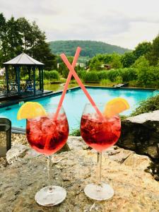 two wine glasses sitting on a table next to a pool at Stará střelnice Hranice in Hranice