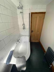 a bathroom with a white sink and a door at Ty Gwyn in Prestatyn