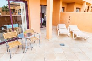 - une terrasse avec une table et des chaises dans un bâtiment dans l'établissement Hotel Oh Nice Caledonia, à Estepona