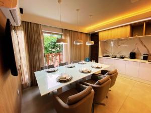 une cuisine et une salle à manger avec une table et des chaises dans l'établissement Flat Île de Pipa Premium - By Almare, à Pipa