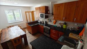 a kitchen with wooden cabinets and a table in it at Penzion Majka in Herálec