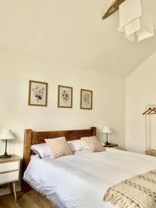 a white bedroom with two beds and two lamps at Converted Barn at Stonehouse Farm 