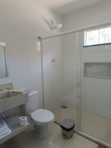 y baño blanco con aseo y ducha. en Pousada Falls Park en Foz do Iguaçu