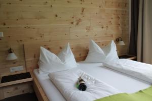 ein weißes Bett mit einer Flasche Champagner drauf in der Unterkunft Landhaus Lenauer in Lermoos