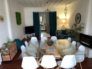 sala de estar con mesa de cristal y sillas blancas en Le Calbanon cilaos, en Cilaos