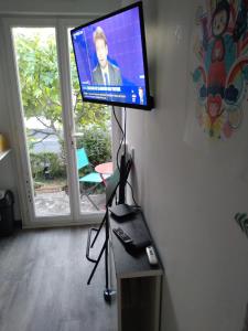 einen Flachbild-TV auf einem Stand in einem Wohnzimmer in der Unterkunft hauts des 2 lions -studio in Joue-les-Tours