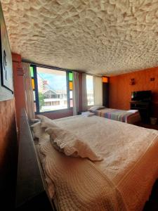 1 dormitorio con 1 cama grande y ventana grande en HOTEL COMPOSTELLA en Paipa