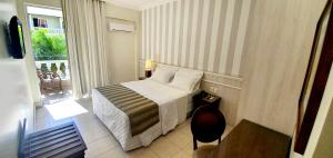 a small hotel room with a bed and a balcony at Hotel Villa Mayor Charme - fortaleza in Fortaleza