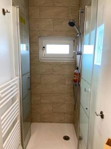 a small bathroom with a shower with a window at La Maison Cabourgeaise proche mer in Cabourg