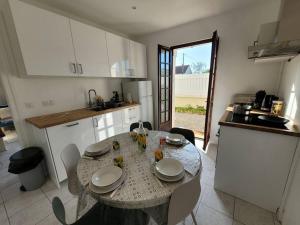 cocina con mesa y sillas en La Maison Cabourgeaise proche mer en Cabourg