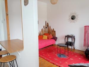 ドゥアルヌネにあるGîte du port Rhuのリビングルーム(赤いソファ、テーブル付)