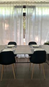 uma mesa de jantar com cadeiras e cortinas brancas em Anna B&B em Ungheni Targ