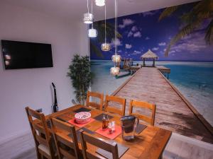 uma sala de jantar com uma mesa e um passeio marítimo em madeira em ASE Premium House em Suceava