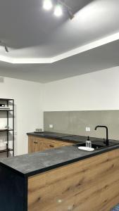 una cocina con encimera negra y fregadero en Anna B&B en Ungheni