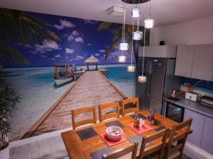uma cozinha com uma mesa de jantar com uma pintura de um cais em ASE Premium House em Suceava