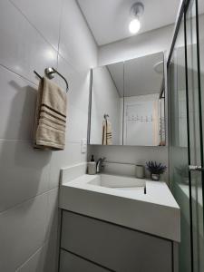 a bathroom with a sink and a mirror at Aconchegante e moderno Studio! Ótima localização! in Curitiba