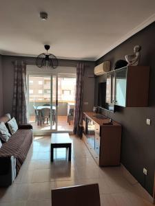 ein Wohnzimmer mit einem Sofa und einem Tisch in der Unterkunft Magic World Apartamento Lyz y Mar in Oropesa del Mar