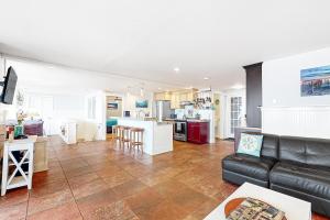 a living room with a couch and a kitchen at Berni's Ocean View Castle - Home Sweet Homestead in Oceanside