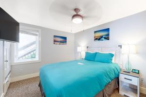 a bedroom with a blue bed and a window at Berni's Ocean View Castle - Home Sweet Homestead in Oceanside