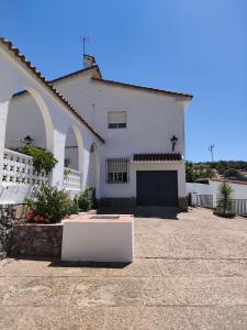 una casa blanca con una puerta y un garaje en Apartamento Pozo Concejo, en Alburquerque
