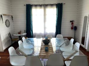 錫拉奧的住宿－Le Calbanon cilaos，一间带桌子和白色椅子的用餐室