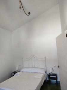 Cama blanca en habitación blanca con 2 mesas en Apartamento Pozo Concejo, en Alburquerque