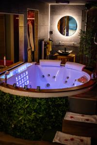 a jacuzzi tub in a bathroom with a mirror at La suite détendue in Saint-Blimont