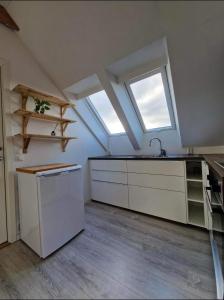 an attic kitchen with a sink and a window at Guesthouse on the footstep of Mount Ulriken in Bergen