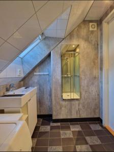 an attic bathroom with a sink and a shower at Guesthouse on the footstep of Mount Ulriken in Bergen