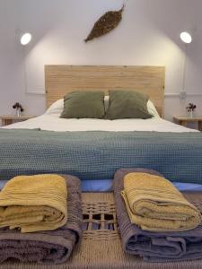 Una cama con mantas y almohadas encima. en Buena Vista Hostel en Humahuaca