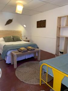 Un dormitorio con una cama y una mesa. en Buena Vista Hostel en Humahuaca