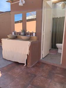 uma casa de banho com 2 lavatórios e um WC em Buena Vista Hostel em Humahuaca