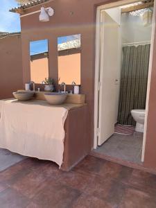 La salle de bains est pourvue de 2 lavabos et de toilettes. dans l'établissement Buena Vista Hostel, à Humahuaca