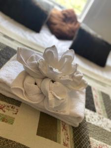 a pile of towels with a flower on a bed at Grand Guesthouse Gardakot in Gardakot