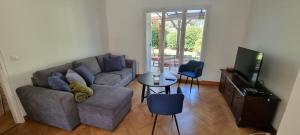 a living room with a couch and a television at Un Havre de Paix in Villepinte