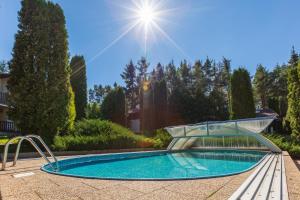 uma piscina num jardim com o sol ao fundo em Apartmány Orlík 2 em Klučenice