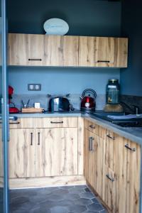 a kitchen with wooden cabinets with pots and pans at La suite détendue in Saint-Blimont
