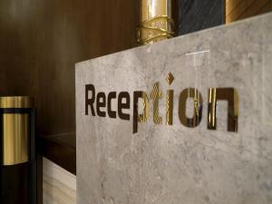 a sign for a hotel lobby with the textrefer to a club at Violet Rose ApartHotel in Jeddah