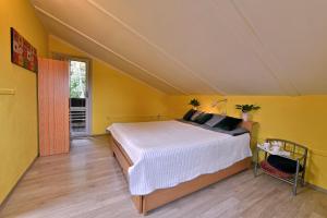een slaapkamer met een bed in een gele kamer bij Apartmány Orlík 2 in Klučenice
