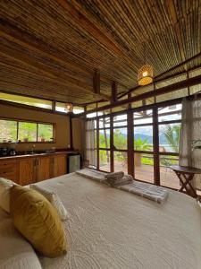 a bedroom with a large bed in a room with windows at Tierra Alta, Refugio de Montaña, Sauce in Sauce