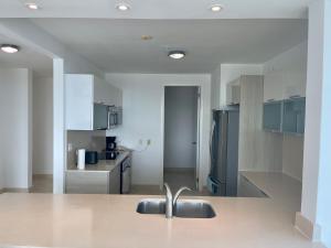 cocina con fregadero y nevera de acero inoxidable en 17E Beautiful 2-Bedroom Ocean View Apartment, en Playa Bonita Village